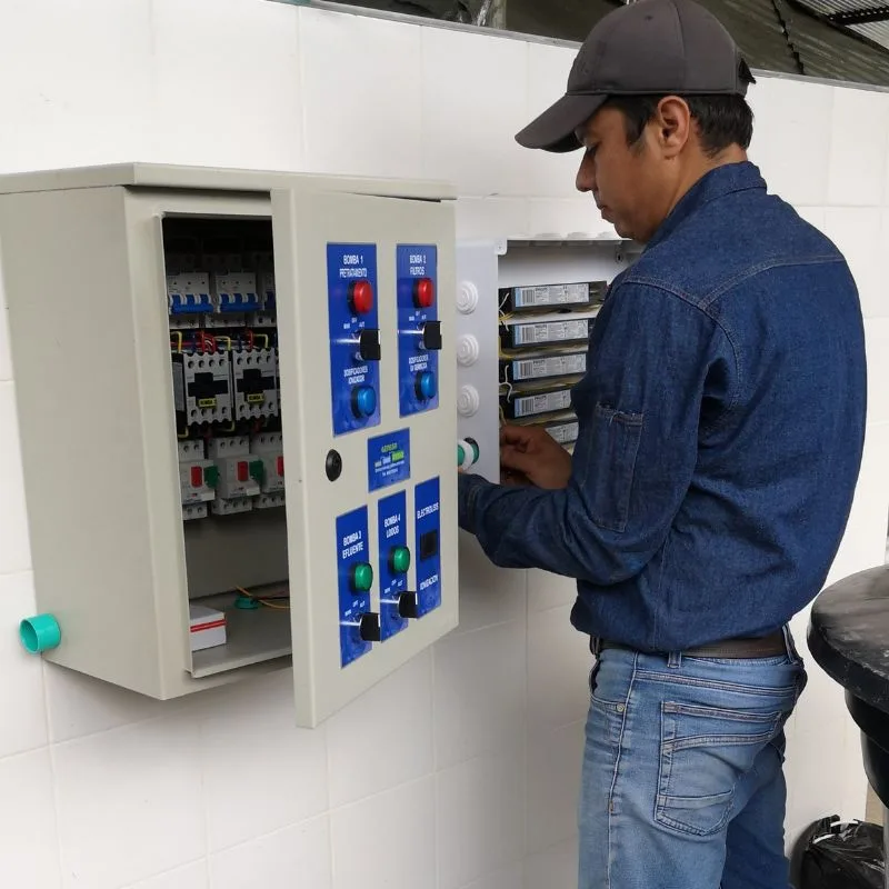 Técnico ajustando sistema de control en planta de tratamiento para gestión sostenible del agua